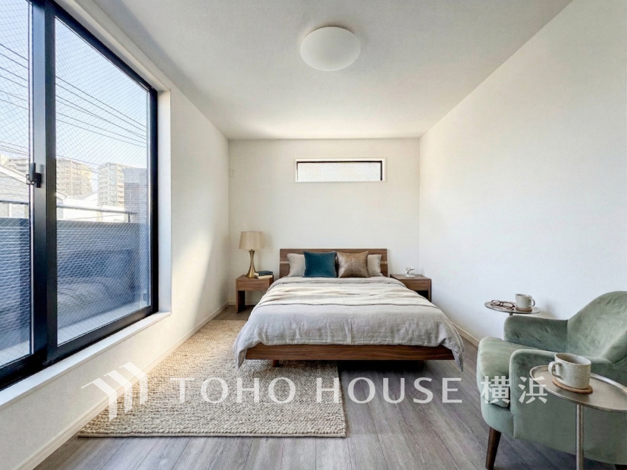 バルコニーに面した明るい洋室。穏やかな陽射しが、ゆったりとした寛ぎの時間を包みます。（家具・装飾品はAI加工です）
