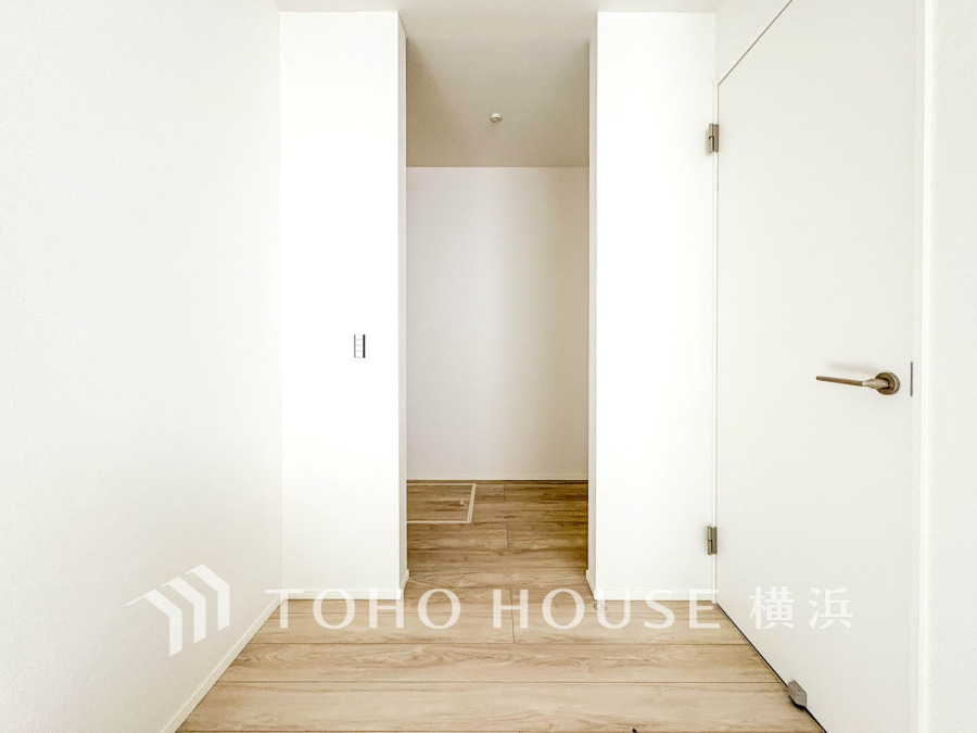 シンプルで清潔感あふれる玄関スペース。白を基調とした壁と木目調の床が温かみを演出します。