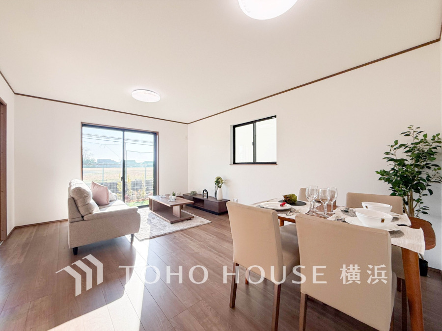 明るい陽射しが差し込む広々リビングダイニング。シンプルで落ち着いた空間が家族の憩いを演出します。