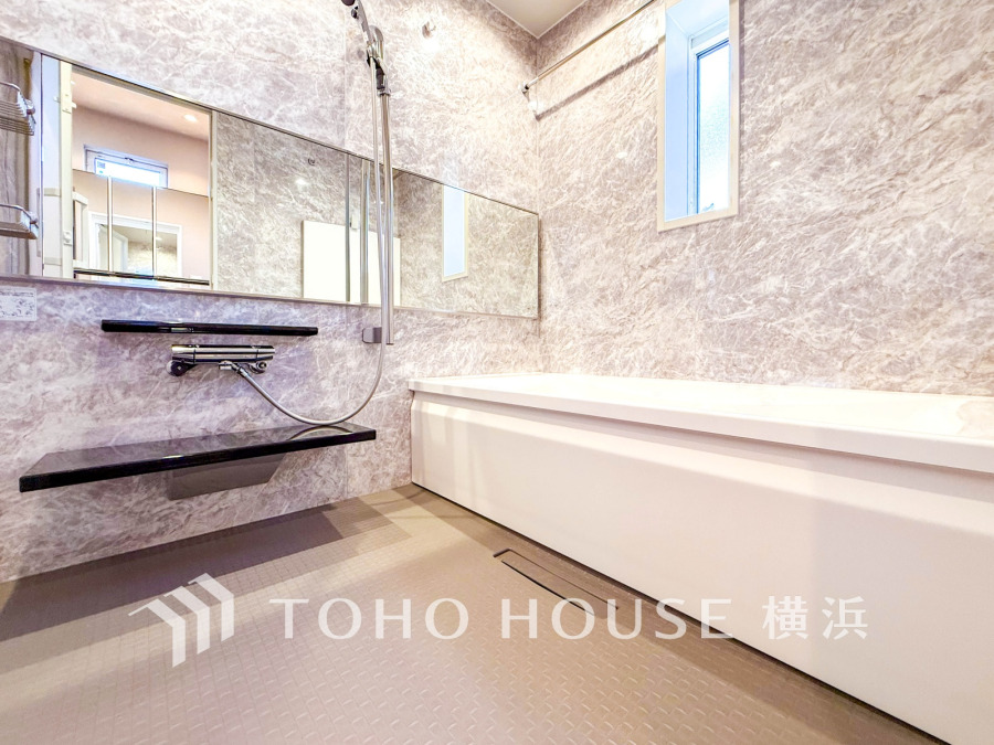 大理石調の壁面が高級感を醸し出す、清潔感あふれるゆったりとしたバスルームです。