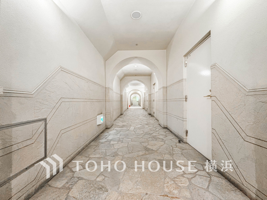 落ち着いた色調とアーチ状の天井が特徴的な、ゆったりとした共有廊下。安全・清潔感のある空間です。