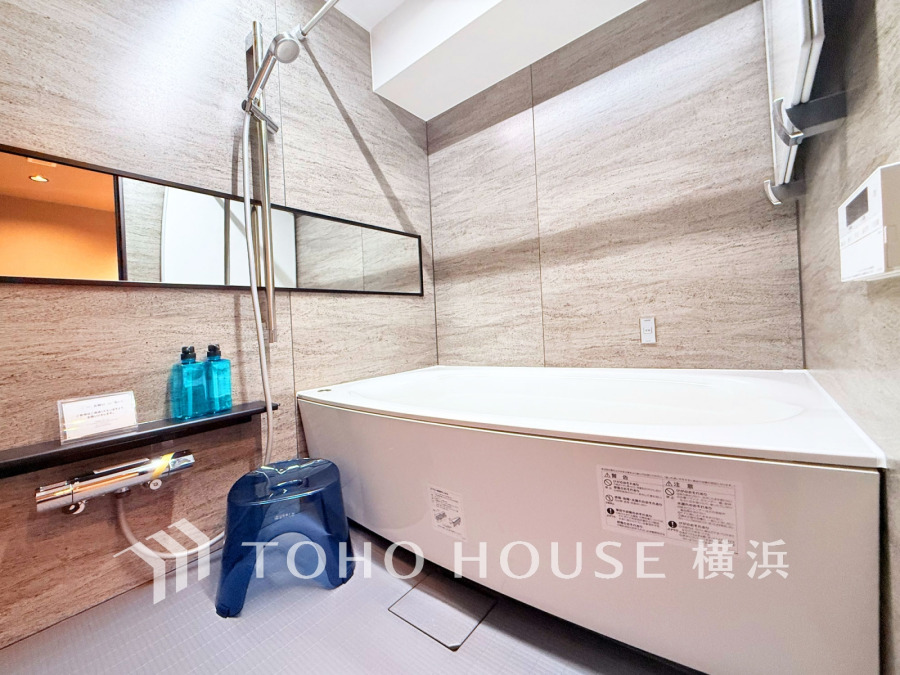 高級感ある壁材と広々浴槽が魅力のバスルーム。ゆったりとリラックスできる空間設計です。