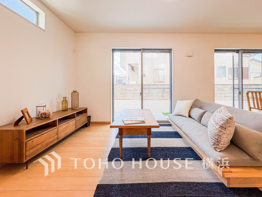 ナチュラルな木質家具と大きな窓からの自然光が心地よい、開放感あふれるリビングルームです。