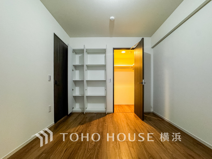 使いやすい収納棚とウォークインクローゼットを備えた、シンプルで落ち着いたデザインの洋室です。