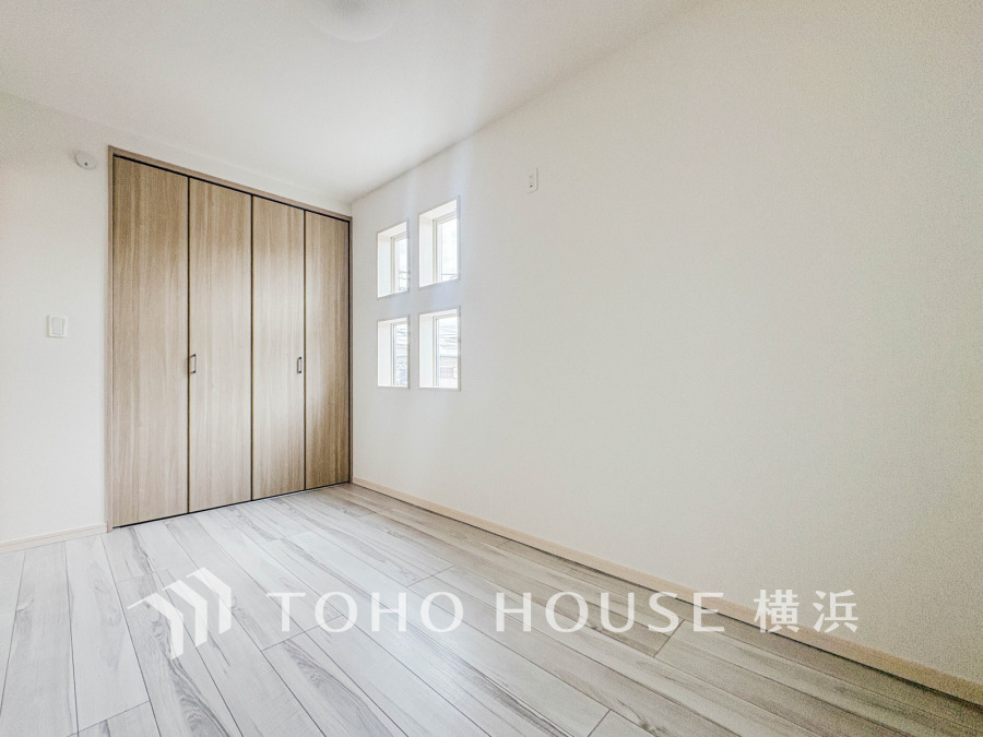 明るい自然光が差し込む、シンプルで清潔感あふれる洋室。収納も充実しています。