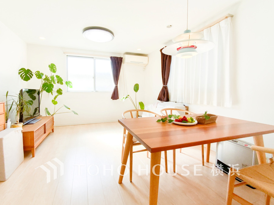 明るい自然光が差し込む、木の温もりとグリーンが調和したナチュラルなリビングダイニング空間です。