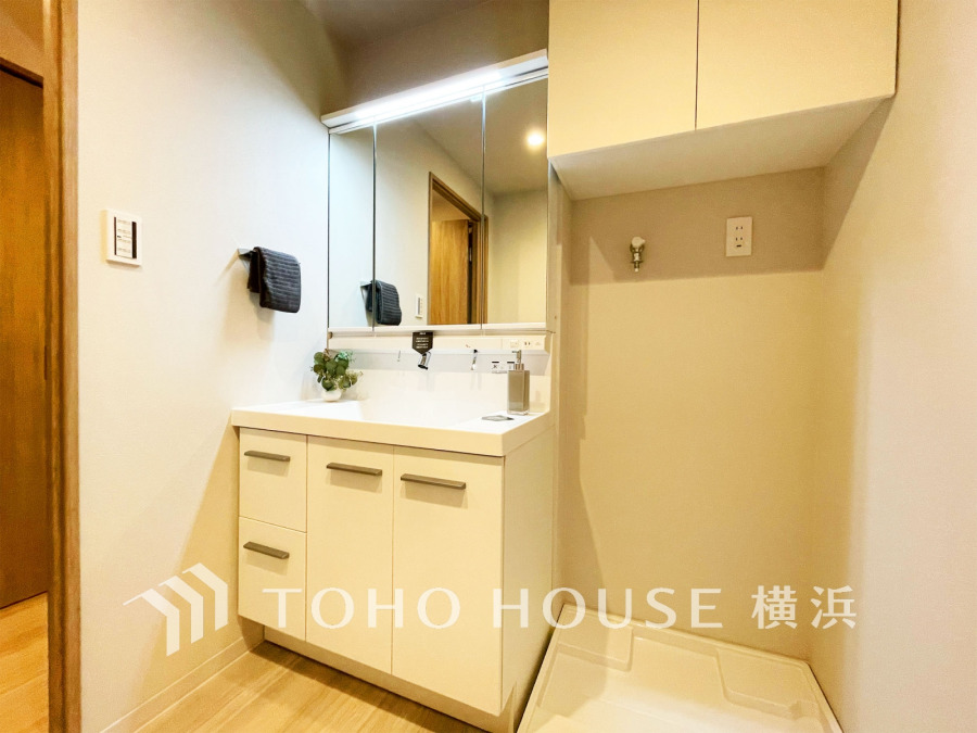 清潔感あふれる洗面台と洗濯機置き場を備えた機能的なサニタリースペース。収納も充実しています。