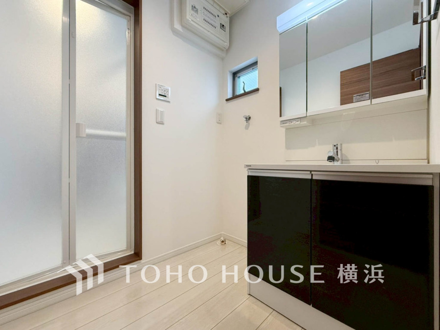 清潔感ある洗面室は収納豊富な鏡付き洗面台と、自然光が差し込む小窓で明るい空間を演出します。