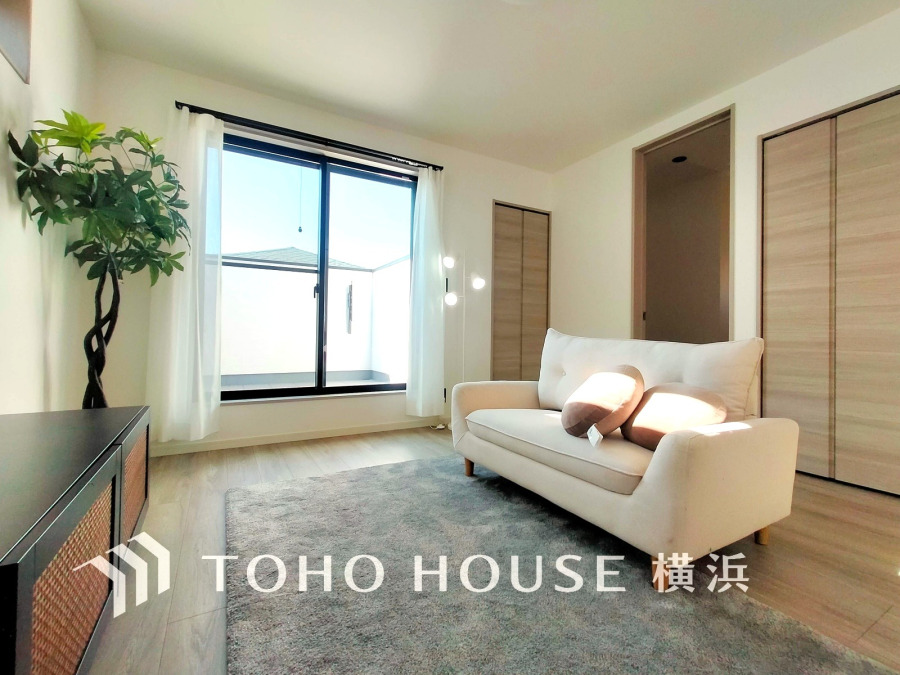 大きな窓から自然光が差し込む明るいリビング。シンプルで落ち着いた空間が魅力です。