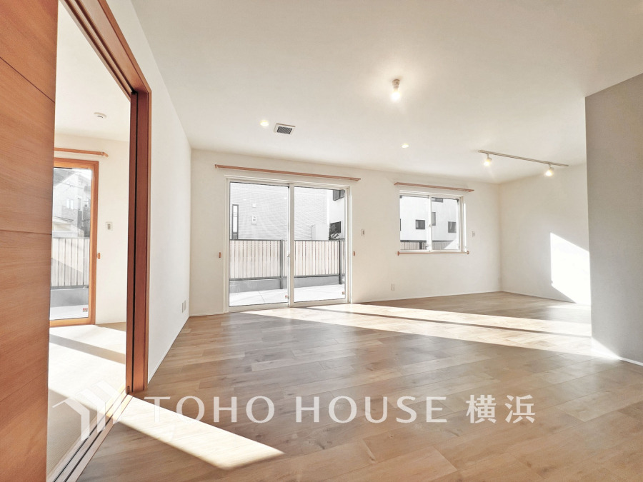 陽光あふれる広々リビング。ナチュラルな木目床と白壁が調和し、快適で開放的な居住空間を演出します。