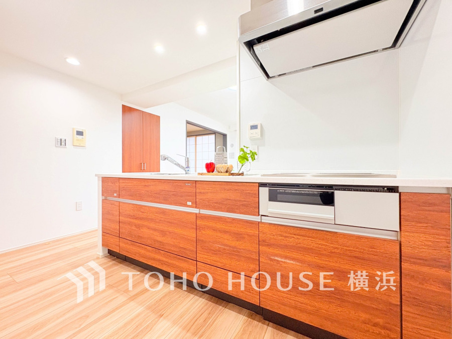 温かみのある木目調のシステムキッチン。広々とした作業スペースで家事が快適に行えます。