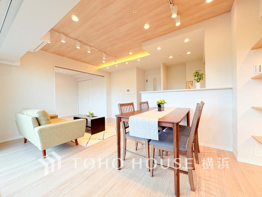 温かみのある木目天井と照明が映える、開放的で明るいリビングダイニング空間です。