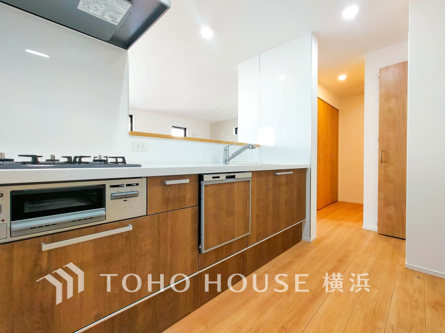 木目調の収納が美しいシステムキッチン。使いやすさと清潔感を兼ね備えた快適な調理スペースです。