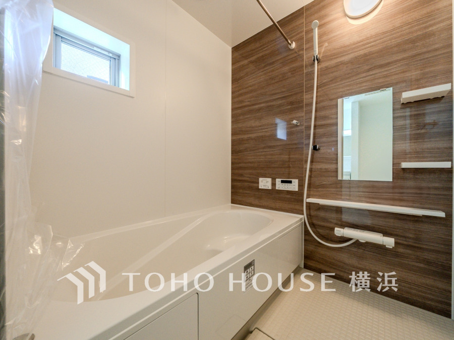 木目調パネルが温かみを演出する清潔感あふれる浴室。快適なバスタイムを提供します。