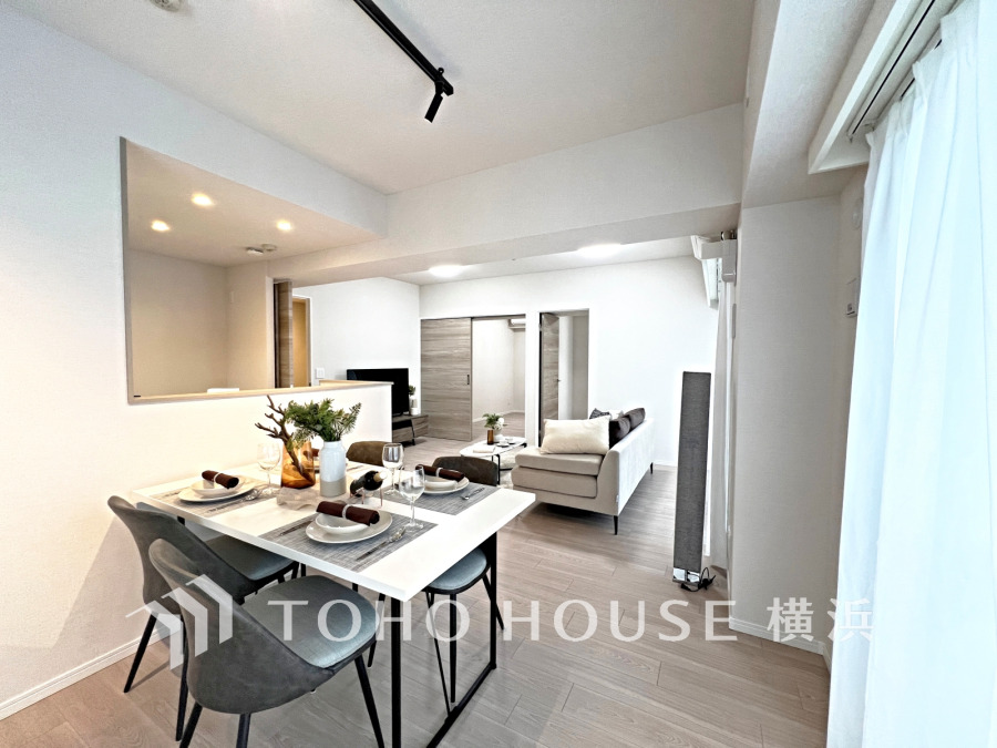 明るい自然光が差し込む、シンプルで落ち着いたダイニングとリビングのある住空間です。