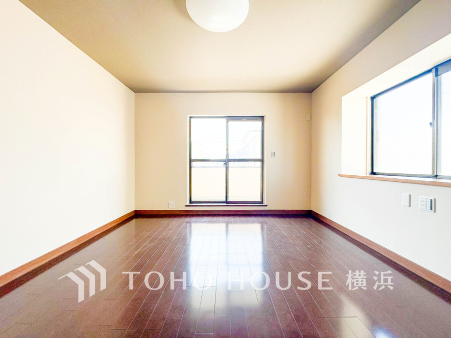 明るい光が差し込むシンプルで広々とした洋室。落ち着いた木目のフローリングが温かみを演出します。