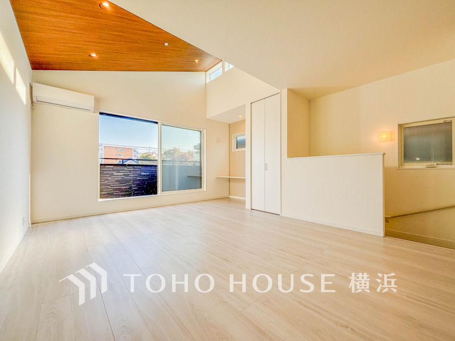 木目天井がアクセントの明るく開放的なリビング。大きな窓から自然光がたっぷり差し込みます。