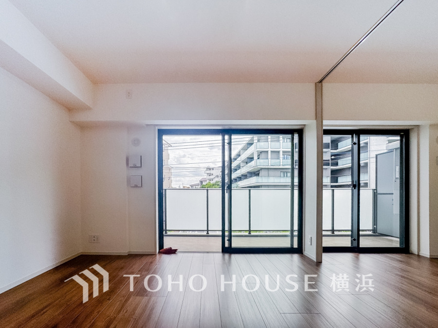 バルコニーに面した大きな窓で明るく開放的なリビング。木目調フローリングが温かみを演出します。