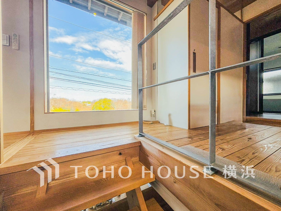 大きな窓から自然光がたっぷり差し込む、温かみのある木質フロアの明るいスペースです。