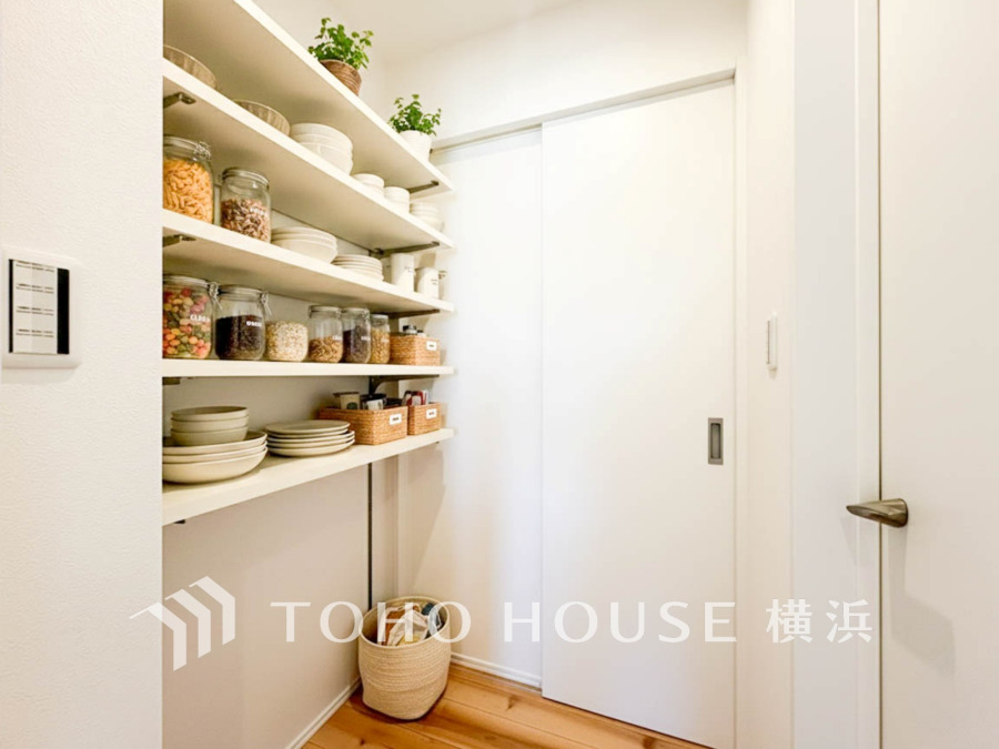 キッチンには、食品庫、パントリーとしてのご利用にお勧めの仕切り棚の付いた使い勝手の良い収納。買い溜め派はもちろんのこと、お料理好きにも嬉しい設備。（家具・調度品はAI加工です）
