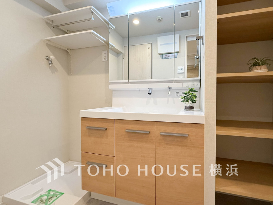 ナチュラルな木目調の洗面台と収納棚が調和する、機能的で清潔感あふれる洗面スペースです。