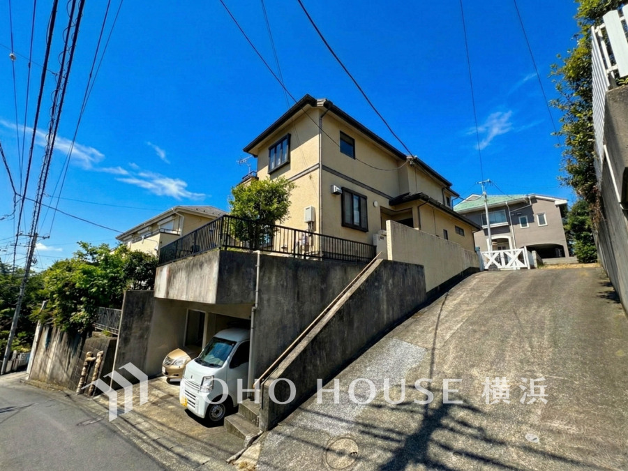 陽当たり良好な高台に立つ2階建て住宅。2台分のガレージ付きで便利な駐車スペースが確保されています。