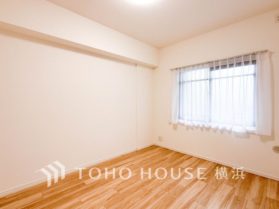 明るい光が差し込む、シンプルで清潔感あふれる洋室。木目調のフローリングが温かみを演出します。