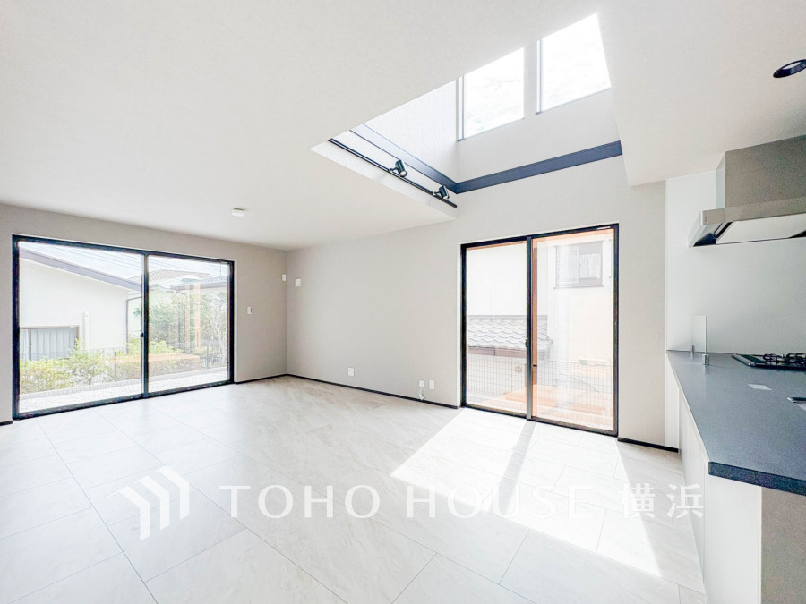 大きな窓と吹抜けから光が差し込む、開放感あふれる明るいリビングダイニング空間です。