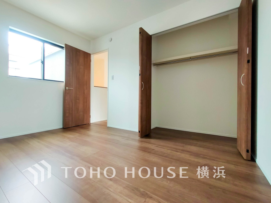 木目調の床と扉が温かみを演出する明るい洋室。大容量の収納スペースで住空間をすっきり保てます。