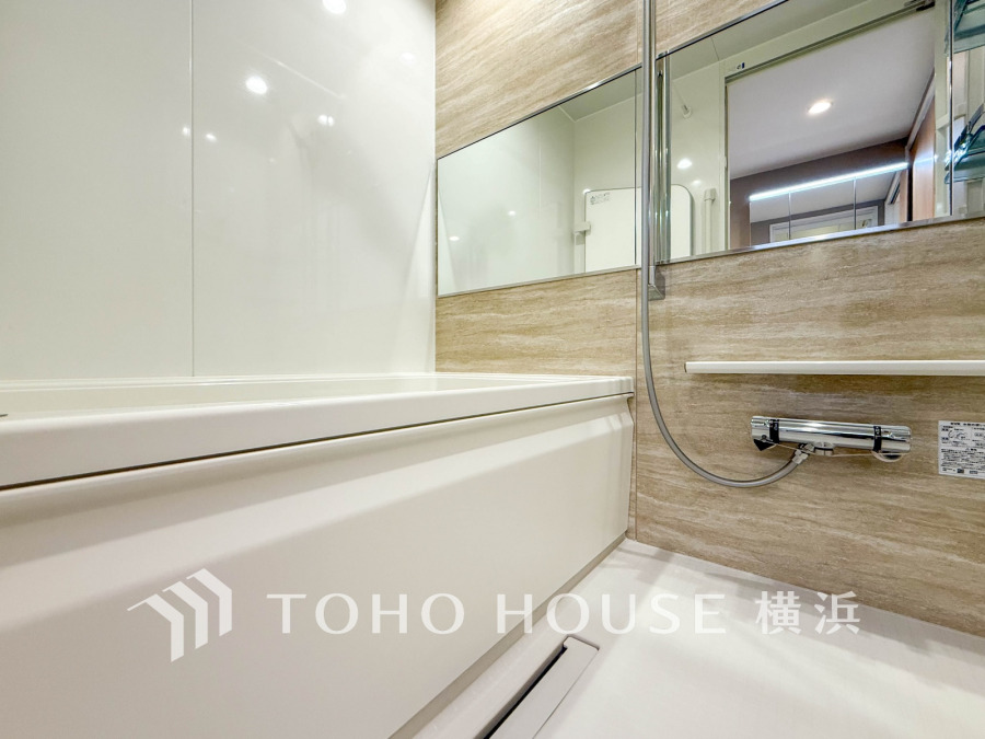 清潔感あふれるシンプルなデザインのバスルーム。大きな鏡で空間に広がりを演出しています。