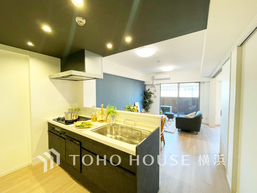 スタイリッシュな対面キッチンから明るいリビングが見渡せ、家族の会話が弾む開放的な空間です。