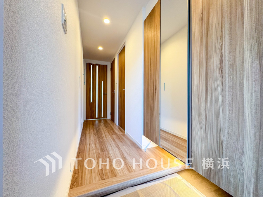 豊富な収納を確保した玄関スペース。便利な大型のミラーのついたシューズボックスを設置。
