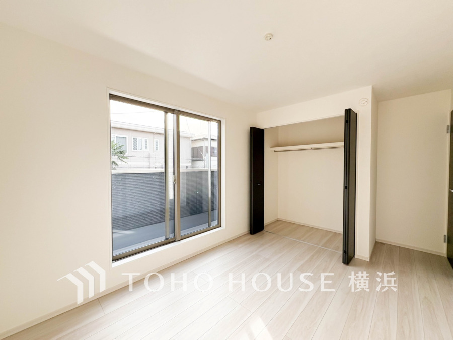 明るい光が差し込むシンプルな洋室。大きなクローゼットとバルコニーに面した窓で開放感があります。