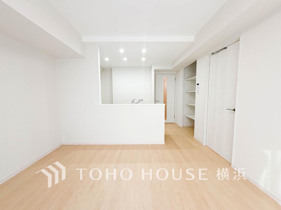 明るい自然光が差し込む、シンプルで清潔感あふれるリビングキッチン空間です。収納も充実しています。