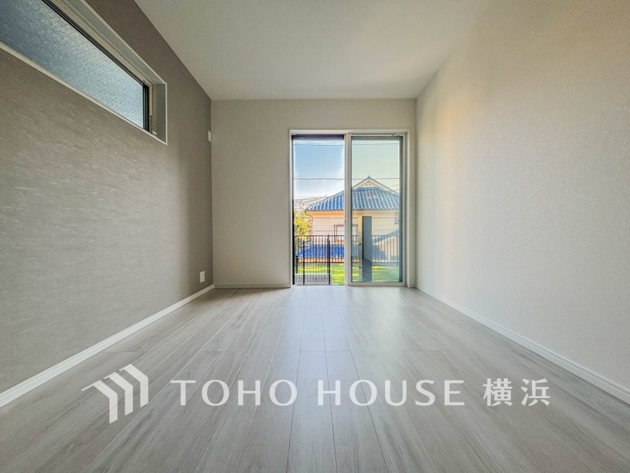 明るい光が差し込むシンプルで落ち着いたデザインの洋室。窓からは庭の緑が望めます。