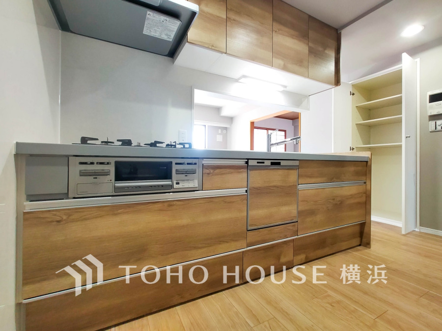 木目調の温かみあるキッチンは収納豊富で使いやすく、開放的な対面式で家族との会話も楽しめます。