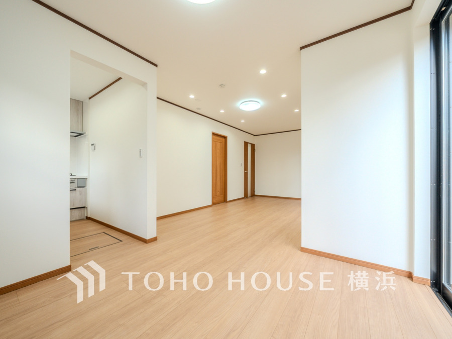 明るく開放的なリビングは、ナチュラルな木目床と白壁で落ち着いた空間を演出しています。