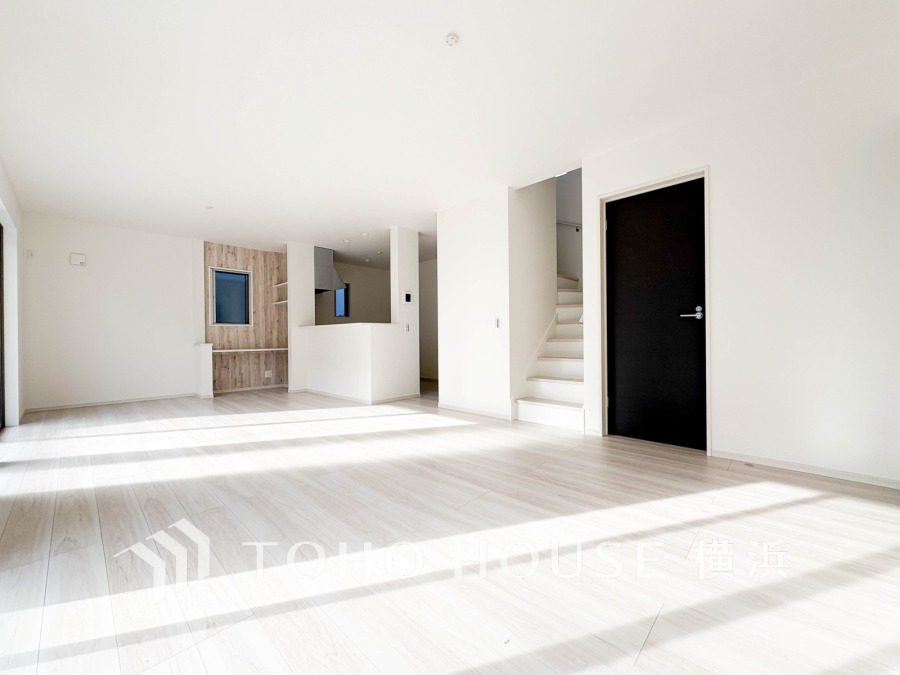 陽光が降り注ぐ広々としたリビング。白を基調にした清潔感あふれる空間で、家族の憩いの場に最適です。