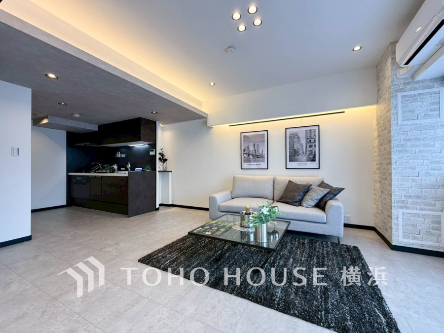 モノトーンを基調としたシンプルで洗練されたリビング。間接照明が落ち着いた空間を演出します。