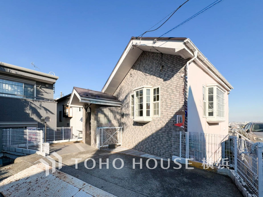 陽当たり良好な高台の閑静な住宅街に立つ、温かみのあるレンガ風の可愛らしい外観。