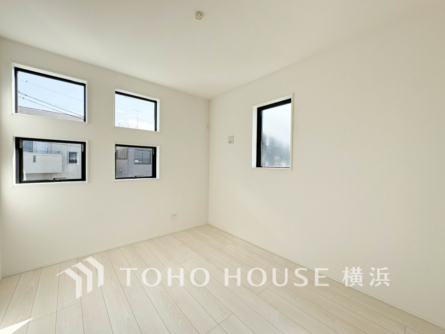 多彩な窓から自然光が注ぐ明るく爽やかな洋室。白さが際立つシンプルで清潔感あふれる空間です。