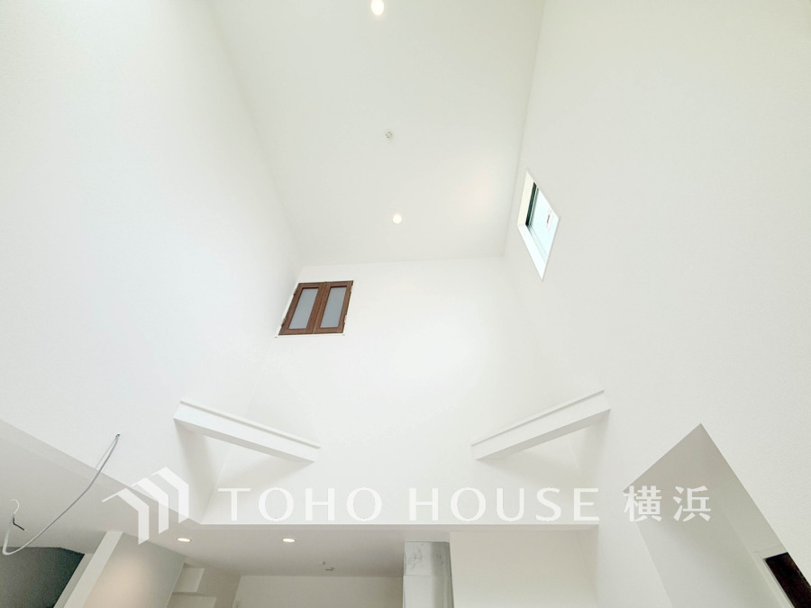 吹き抜けと高窓が彩る開放的な住空間。集いの場にふさわしい優雅さと落ち着きを兼ね備えたリビングです。
