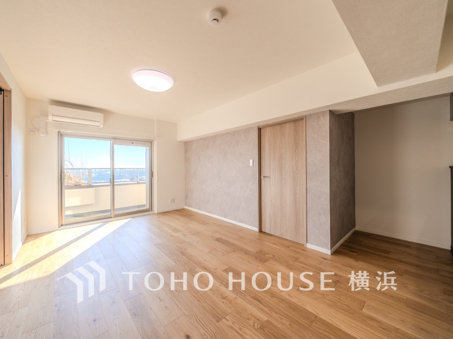 陽光が差し込む広々としたリビング。バルコニーからの眺望も楽しめる快適な住空間です。