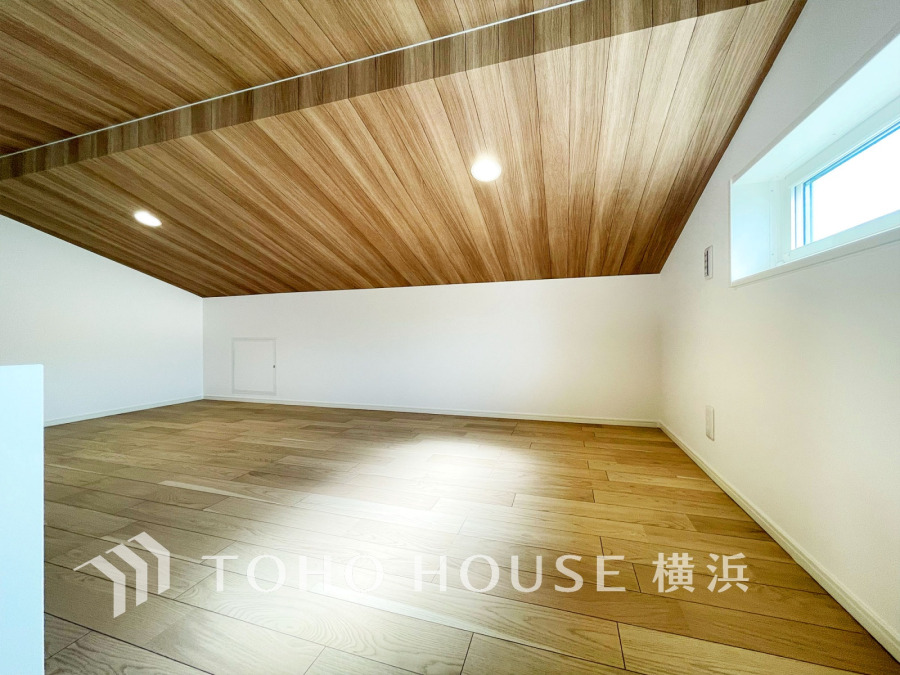 木目調の天井と床が温かみを演出する、明るく開放的なロフトスペースです。収納や趣味部屋に最適です。
