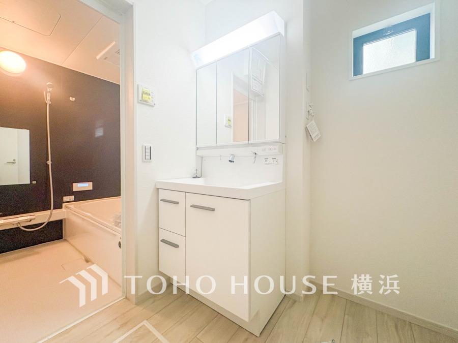 清潔感あふれる洗面スペースと独立した浴室。明るい窓から自然光が入り、快適なバスタイムを実現します。