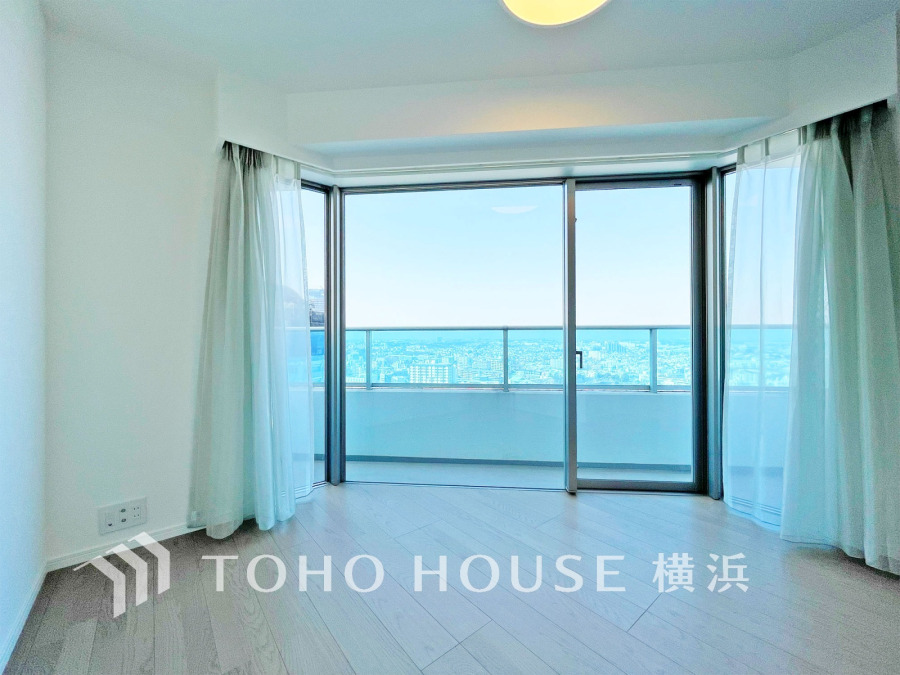 大きな窓から青空と街並みを望む明るく開放的なリビング。自然光がたっぷり差し込みます。