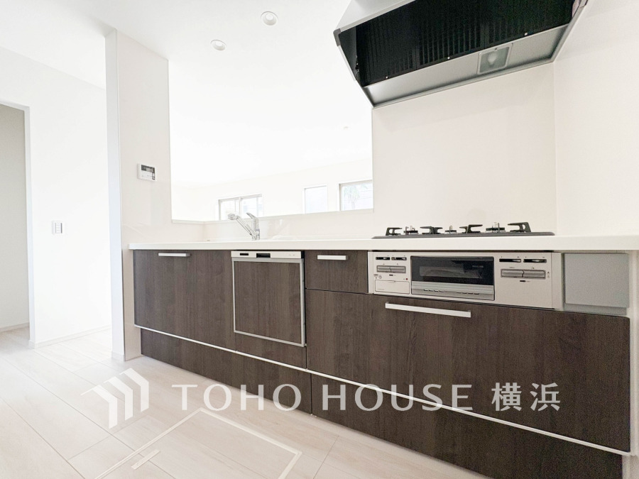 落ち着いた木目調のキッチンは収納豊富で、使いやすさと清潔感を兼ね備えた快適な料理空間です。