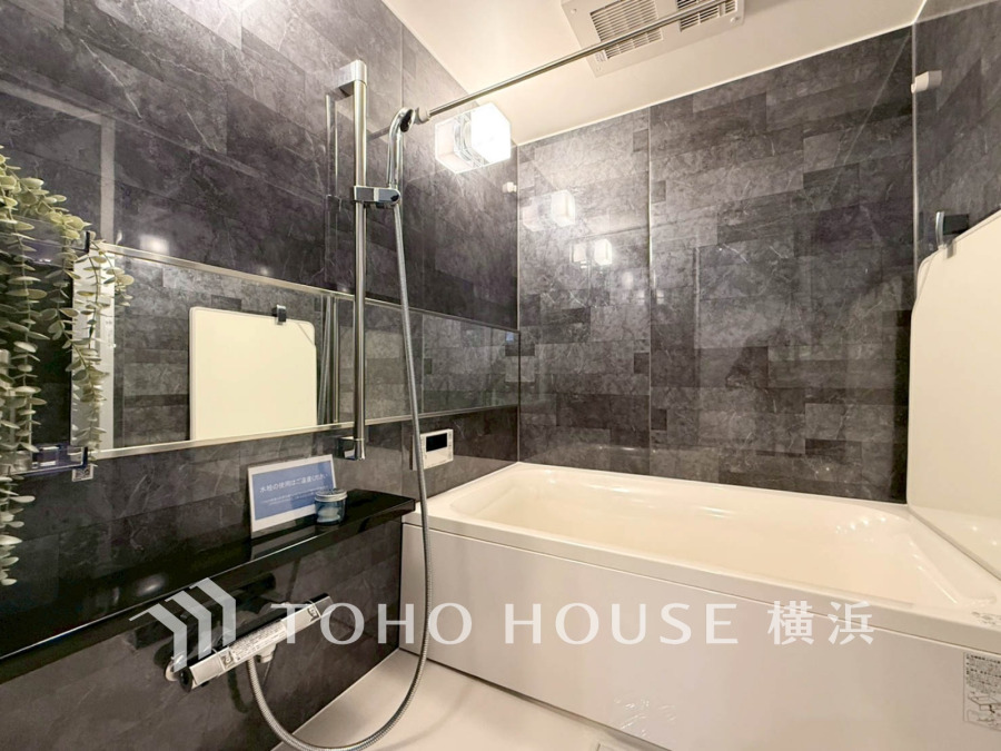 落ち着いたダークトーンの壁面が高級感を演出する、ゆったりくつろげるバスルームです。