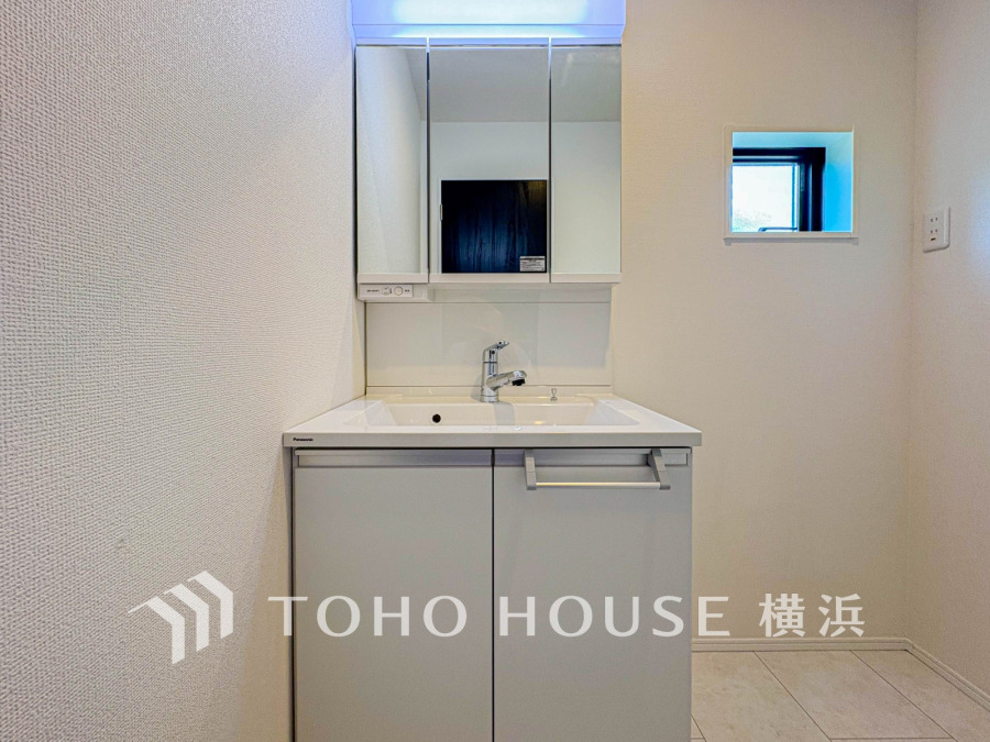 シンプルで清潔感のある洗面台。鏡裏収納と小窓で使いやすさと通風を両立した快適な空間です。