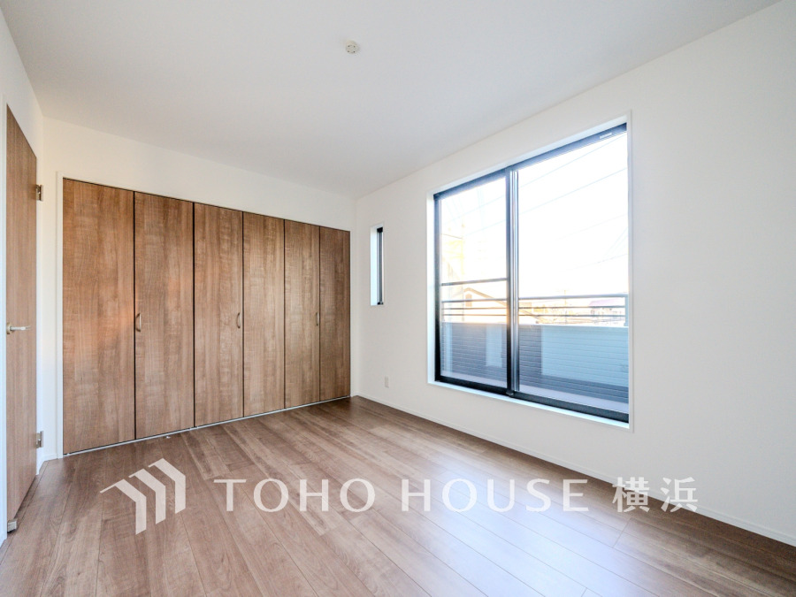 バルコニーから明るい自然光が差し込む洋室。大型クローゼット付きで収納も充実しています。
